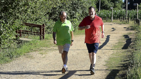 El presidente del Gobierno en funciones, Mariano Rajoy, junto a José Benito Suárez, marido de la presidenta del Congreso de los Diputados, Ana Pastor, caminando por la Ruta da Pedra e da Agua, en Pontevedra. Archivo EFE