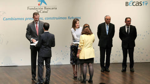 Los Reyes Felipe VI y Letizia, y el presidente de La Caixa Isidrto Fainé, durante la ceremonia de entrega de las becas de posgrado de La Caixa. EFE/Ballesteros