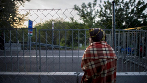 Una mujer observa la frontera entre Serbia y Hungría en Roszke. /EFE