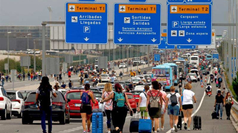 Varios viajeros llegan caminando al Aeropuerto del Prat después de que la plataforma Tsunami Democràtic haya llamado a paralizar la actividad del aeropuerto. (QUIQUE GARCÍA | EFE)