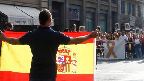 14/10/2019.- Un hombre con una bandera de España se encara con los centenares de personas que cortan la céntrica Via Laietana de Barcelona en protesta por la sentencia del 'procés'. / EFE -