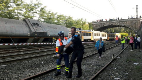 Policías y trabajadores trasladan a un herido tras el accidente en el que ha descarrilado un tren en O Porriño, Galicia. REUTERS/Vigoalminuto.com