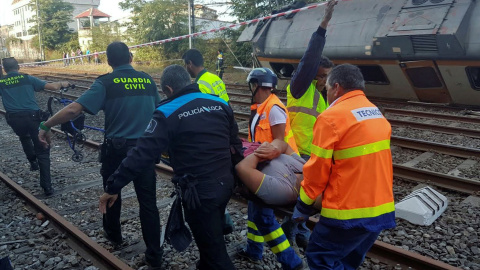 Policías y trabajadores trasladana  un herido tras el accidente del tren que ha descarrilado en O Porriño, Galicia. REUTERS/Vigoalminuto.com