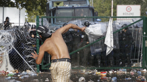 Migrantes reaccionan a los gasos lacrimógenos lanzados por la Policía húngara. REUTERS