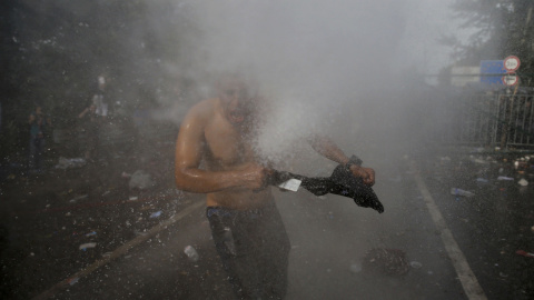 Un migrante es golpeado por un chorro del cañón de agua utilizado por la policía antidisturbios húngara en la parte serbia de la frontera, cerca de Röszke. REUTERS