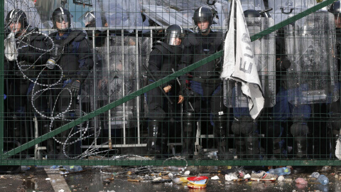 Agentes antidisturbios húngaros observan a los refugiados desde el otro lado de la frontera con Serbia. REUTERS