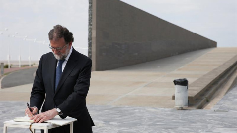 El presidente del Gobierno, Mariano Rajoy, firma en el libro de honor a las victimas de la dictadura argentina durante su visita al Parque de la Memoria. / EFE