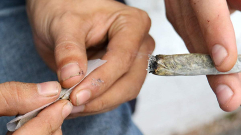 Un hombre prepara un cigarro de marihuana. EFE