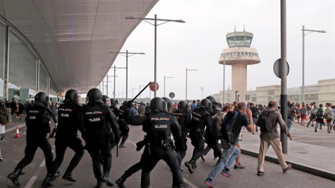 Miembros de la Policía Nacional cargan contra los centenares de personas que se agolpan ante el Aeropuerto del Prat después de que la plataforma Tsunami Democràtic haya llamado a paralizar la actividad del aeropuerto. /EFE