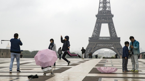 Dos turistas nipones se toman fotos delante de la torre Eiffel en Trocadero, París (Francia). EFE/Archivo