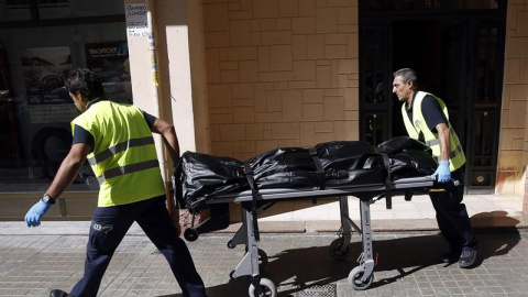 Operarios del servicio funerario transportan el cuerpo de la mujer de 42 años muerta acuchillada por su pareja que conoció por Internet . EFE/Kai Försterling