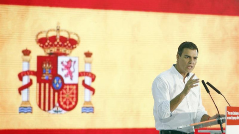 Pedro Sánchez con la bandera rojigualda durante el acto. EFE/Andreu Dalmau