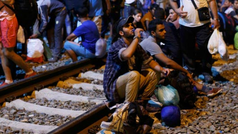 Un grupo de refugiados espera en la estación de la ciudad fronteriz de Tobarnik. / ANTONIO BRONIC (REUTERS)