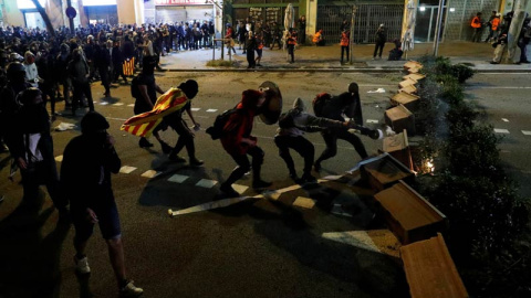 Varios manifestantes montan una barricada en el centro de Barcelona, (REUTERS)