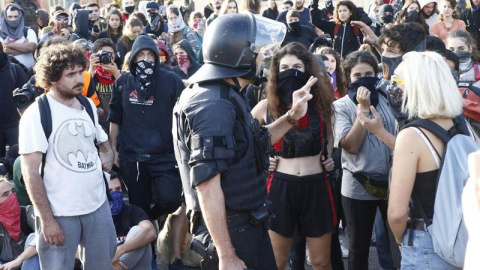 Un mosso se dirige a un grupo de estudiantes en Barcelona. (QUIQUE GARCÍA | EFE)