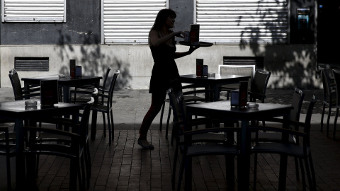 Una mujer atiende una terraza en el centro de Madrid. REUTERS