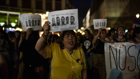 Una mujer muestra las caras de los cinco integrantes de 'la manada' durante la manifestación contra su sentencia condenatoria en Madrid.- JAIRO VARGAS