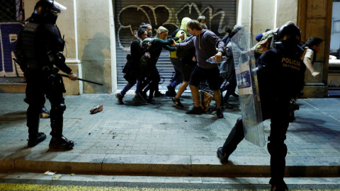 Varios jóvenes corren ante los Mossos durante los disturbios producidos en Barcelona. /REUTERS