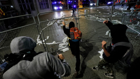 Varios hombres encapuchados lanzan objetos ante los furgones policiales en el centro de Barcelona. /REUTERS