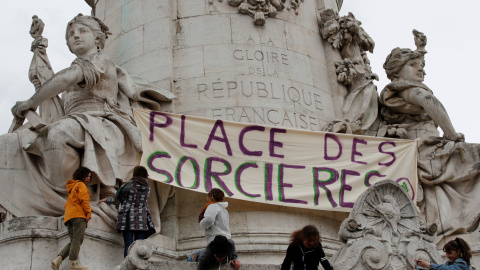 Un grupo de mujeres cuelga un cartel en la estatua de la Plaza de la República en la que se puede leer: "Plaza de las brujas".  REUTERS/Philippe Wojazer