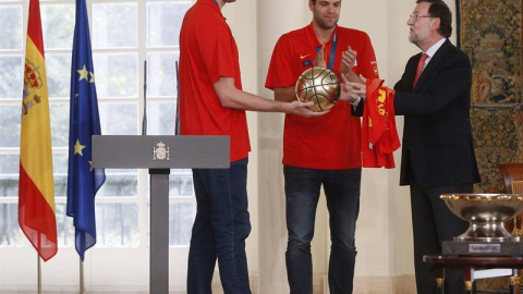 Pau Gasol, junto a Felipe Reyes, le entrega un balón de oro a Mariano Rajoy en La Moncloa. /EFE