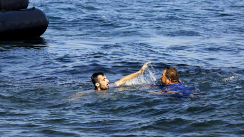 Un voluntario griego se tira al agua tras él también sin chaleco salvavidas para salvarle./ EUROPA PRESS