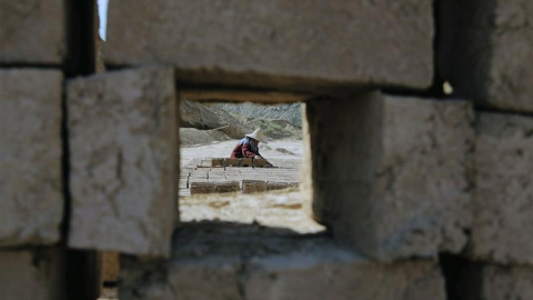 Un inmigrante afgano trabaja en una fábrica de ladrillos en la ciudad de Varamin, Irán. Los empleados de estas fábricas trabajan casi 14 horas por 10 dólares al día y solo realizan esta actividad durante los seis meses en los que el tiempo 