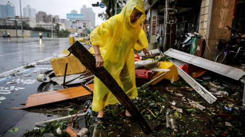 Un hombre busca objetos reutilizables entre los escombros provocados por el azote del viento y la lluvia del supertifón Meranto en Kaohsiung, Taiwán. EFE/Ritchie B. Tongo