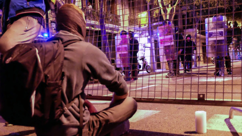 Manifestantes de los CDR, sentados pacíficamente con velas encendidas ante las vallas que después derribarían los infiltrados, provocando incidentes y cargas policiales. SERGI CAMARA