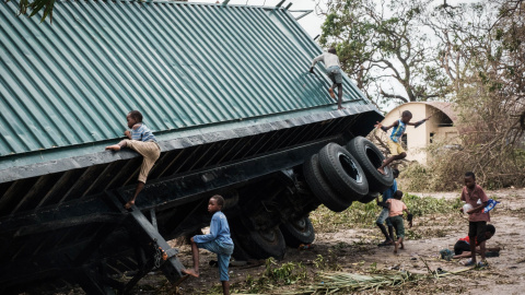 Unos niños juegan en un contenedor volcado por el ciclón Idai en Beira, Mozambique, el 21 de marzo de 2019  | AFP/ Yasuyoshi Chiba