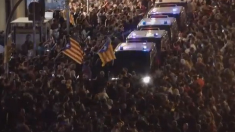 Furgones policiales se abren paso entre los manifestantes concretados en Via Laietana, en Barcelona.- CAPTURA