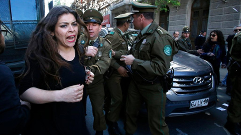 Imagen de la detención de una mujer en las protestas de Chile