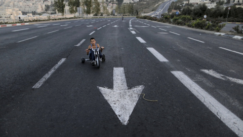 Un niño montado en su triciclo en una calle desierta durante la fiesta judía  Yom Kippur. REUTERS/Ammar Awad