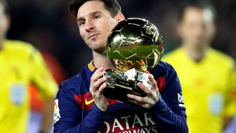 El delantero del Barcelona Lionel Messi ofrece su quinto Balón de Oro a la afición. /EFE