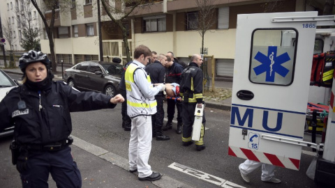 Un agente de Policía da indicaciones en las inmediaciones de la revista 'Charlie Hebdo'. /AFP