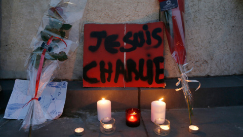 Flores , velas y un cartel que dice "Yo soy Charlie " rinden homenaje en la Plaza de la República de París a las víctimas del atentado contra la revista satírica. -REUTERS