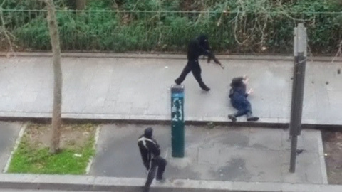 Imagen de un video amateur en el que se ve a uno de los atacantes de la revista 'Charlie Hebdo' disparando contra un policía que yace herido en el suelo. REUTERS