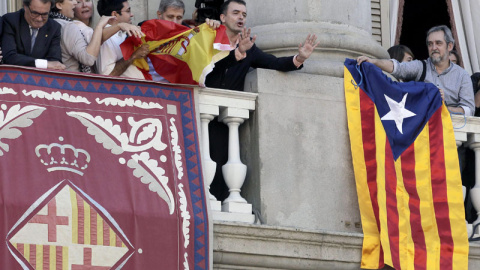 Momento en el que Alberto Fernández Díaz, del PP,  intenta sacar la bandera española en el balcón del Ayuntamiento de Barcelona. / EFE