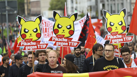 Diversas personas se manifiestan en Frankfurt contra el TTIP y el CETA con carteles que dicen: "Pikachu también está en contra del TTIP". REUTERS/Kai Pfaffenbach