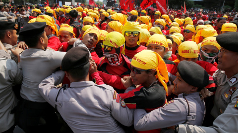 Trabajadores inonesios se enfrentan a los policías para poder acceder al distrito financiero de Yakarta, en la manifestación del Primero de Mayo.. REUTERS/Beawiharta