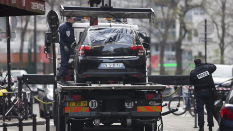 Agentes de Policía retiran el supuesto coche utilizado por los atacantes a la sede de 'Charlie Hebdo' en París. - EFE