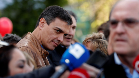 El secretario general del PSOE, Pedro Sánchez, observa al candidato socialista a la Comunidad de Madrid, Ángel Gabilondo, antes de su participación en la manifestación que se celebra en Madrid con motivo del Primero de Mayo. EFE/Chema Moya