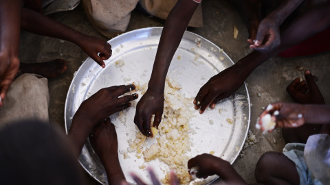 Niños desplazados comen arroz de un plato compartido en Kenya. CARL DE SOUZA (AFP)