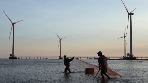 Varios pescadores trabajan junto a la primera instalación de energía eólica de Vietnam. DUY KHOI (AFP)