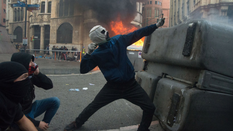 Un joven encapuchado a la mexicana lanza bolas de acero con un tirachinas contra los policías que rodean la comisaría de Vía Layetana de Barcelona. GUILLEM SANS