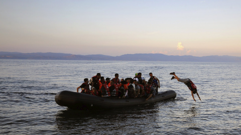 Refugiado sirio se tira al mar cuando su embarcación se acerca a una playa de la isla griega de Lesbos, después de cruzar el Mar Egeo. REUTERS