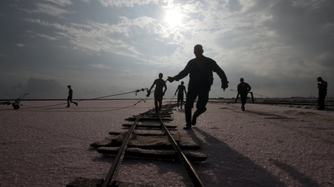 Trabajadores ajustan unos carriles en el área drenada de un lago en Sasyk (Crimea) utilizados para la producción de sal. REUTERS