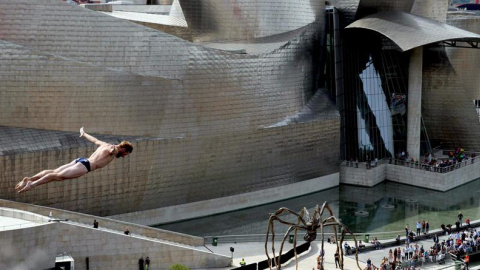 El clavadista estadounidense Andy Jones durante la ronda clasificatoria para la final de la prueba del 'Red Bull Cliff Diving 2015' de Bilbao, ante el Museo Guggenheim de la capital vizcaína. EFE/LUIS TEJIDO