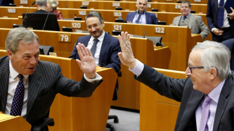 El presidente de la Comisión Europea, Jean-Claude Juncker, saluda al eurodiputado euroescéptico Nigel Farage, antes del debate sobre el escenario presupuestario de la UE, en el Parlamento Europeo, en Bruselas. REUTERS/Francois Lenoir