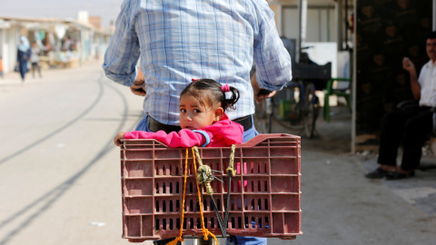 Un refugiado sirio monta una bicicleta con su hija en el campo de refugiados de Al- Zaatri en la ciudad jordana de Mafraq. REUTERS/Muhammad Hamed